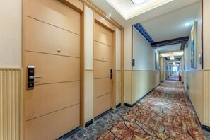 A hotel hallway with doors, carpeted flooring, and a ceiling light fixture. - Beihaidao Hotel (Shenzhen Shuangyong Street Metro Station) (Shenzhen)