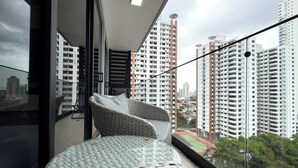 A balcony with wicker furniture and a city view. - Modern and cozy apartment in the heart of Panama City, ideal for business travelers and digital nomads. Pool, gym, and coworking space available, with valet parking offered as an optional service. (Panamá)