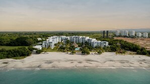 Un complejo turístico con varias edificaciones, una playa y una piscina.
