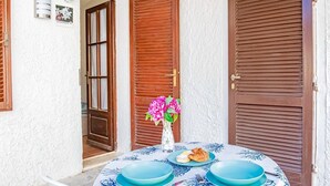 A table set with plates, a vase with flowers, and a croissant. - Villa Bouganville   Il Gelsomino (CAPOLIVERI)