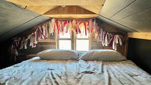 Une chambre à coucher avec un lit, des oreillers et une fenêtre.