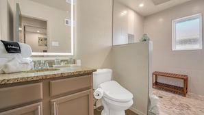 Een moderne badkamer met toilet, wastafel en douche.