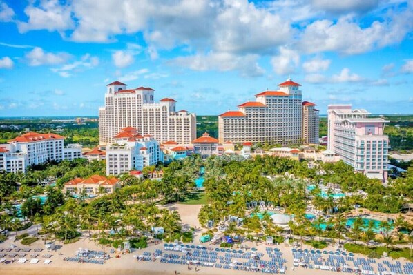 A resort with multiple high-rise buildings, a beachfront, and a pool area.