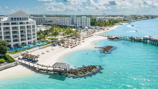 A resort with a beachfront, a pool, and a pier.