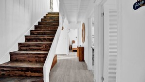 A staircase with wooden steps leading to a landing, white walls, and a hallway with a door labeled "place".