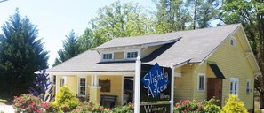 A yellow building with a sign reading "Slightly Askew Winery" and a sign indicating "21 mins to Slightly Askew Winery." - The Farmhouse. Vintage 3-bedroom with WiFi. Mt Airy outskirts. Vineyards nearby. (Mount Airy)