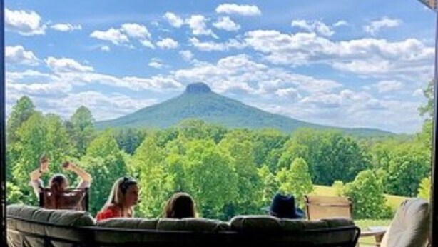 Blick von einer überdachten Terrasse mit einem Berg im Hintergrund.