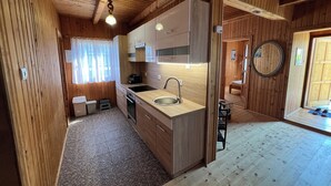 Uma cozinha compacta com paredes de madeira, pia e fogão.