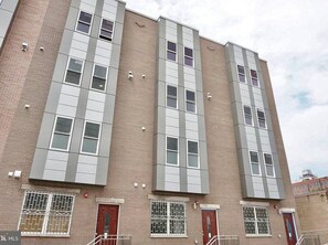 A multi-story building with a brick facade, large windows, and a flat roof.