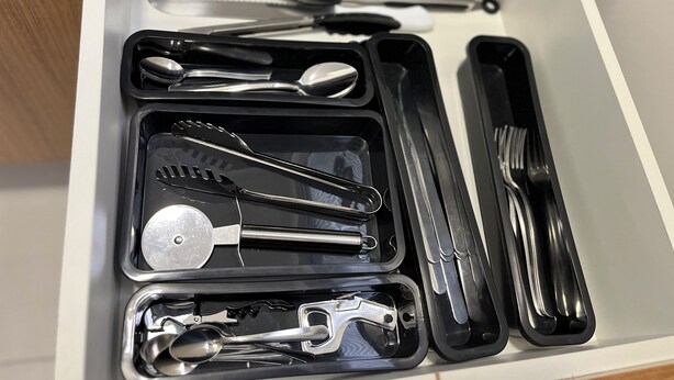 A drawer with neatly organized kitchen utensils including tongs, spoons, and a spatula. - Toque a Campainha 207 Vendaval (Cabo Frio)