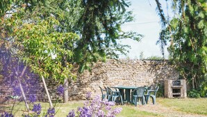 A stone wall, outdoor seating, and purple flowers. - Potager country house in the heart of the Charolais in southern Burgundy (Baron)