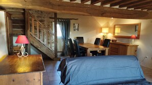 A cozy room with a bed, desk, and chair, a staircase, and a wooden ceiling. - Potager country house in the heart of the Charolais in southern Burgundy (Baron)