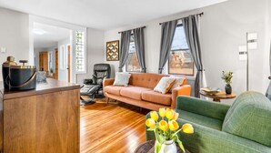 A modern living room with a sofa, a green armchair, a massage chair, and a wooden coffee table. - #30 - Spacious & Cozy! (Southington)
