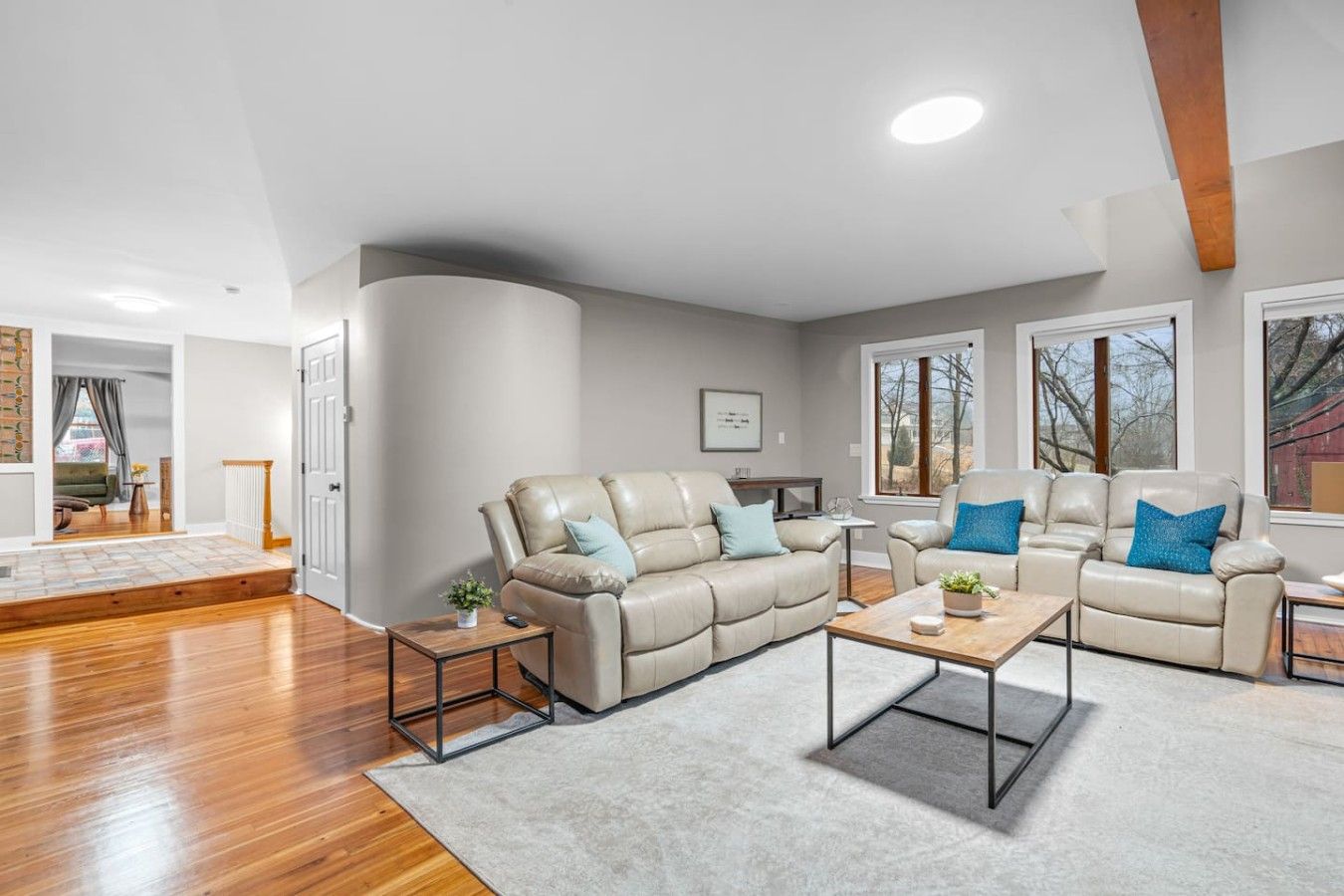 A modern living room with a sectional sofa, a coffee table, and a fireplace.
