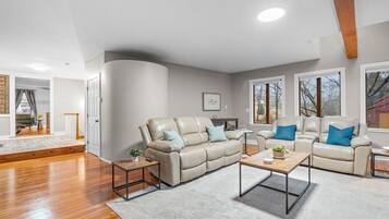 A modern living room with a sectional sofa, a coffee table, and a fireplace.