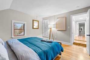 A bedroom with a bed, a window, a lamp, and a door leading to another room. - #30 - Spacious & Cozy! (Southington)