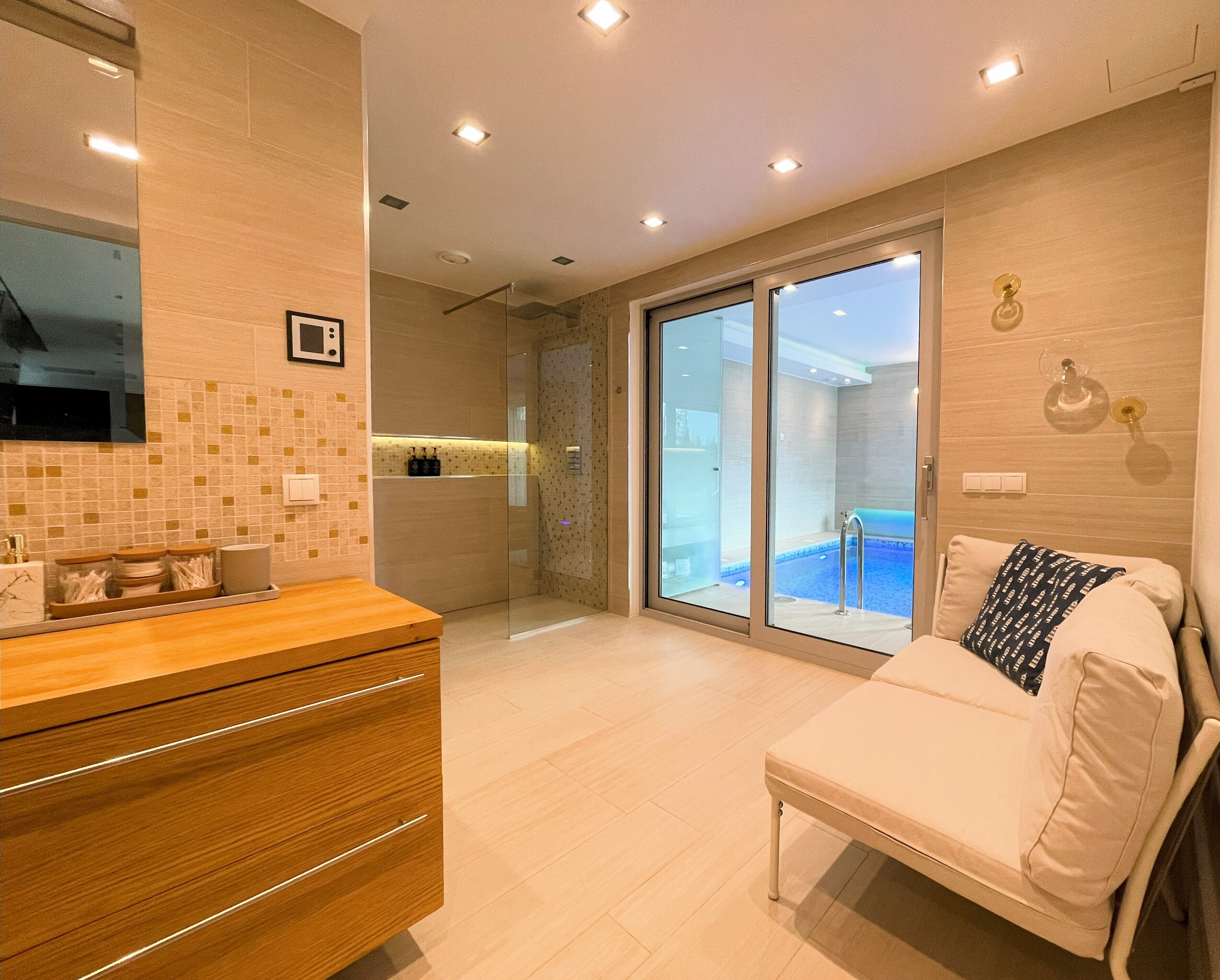 A modern bathroom with a glass shower enclosure, a wooden vanity, and a large mirror.