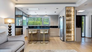 Una cocina moderna con barra, sofá y una vitrina para cristalería.