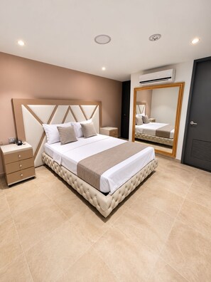 Une chambre moderne avec un grand lit, des tables de chevet, un miroir et un appareil de climatisation.