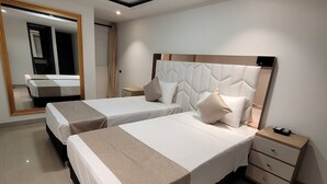A modern hotel room with two beds, a large mirror, a bedside table, and a nightstand. - Hotel Med 33 (Medellín)