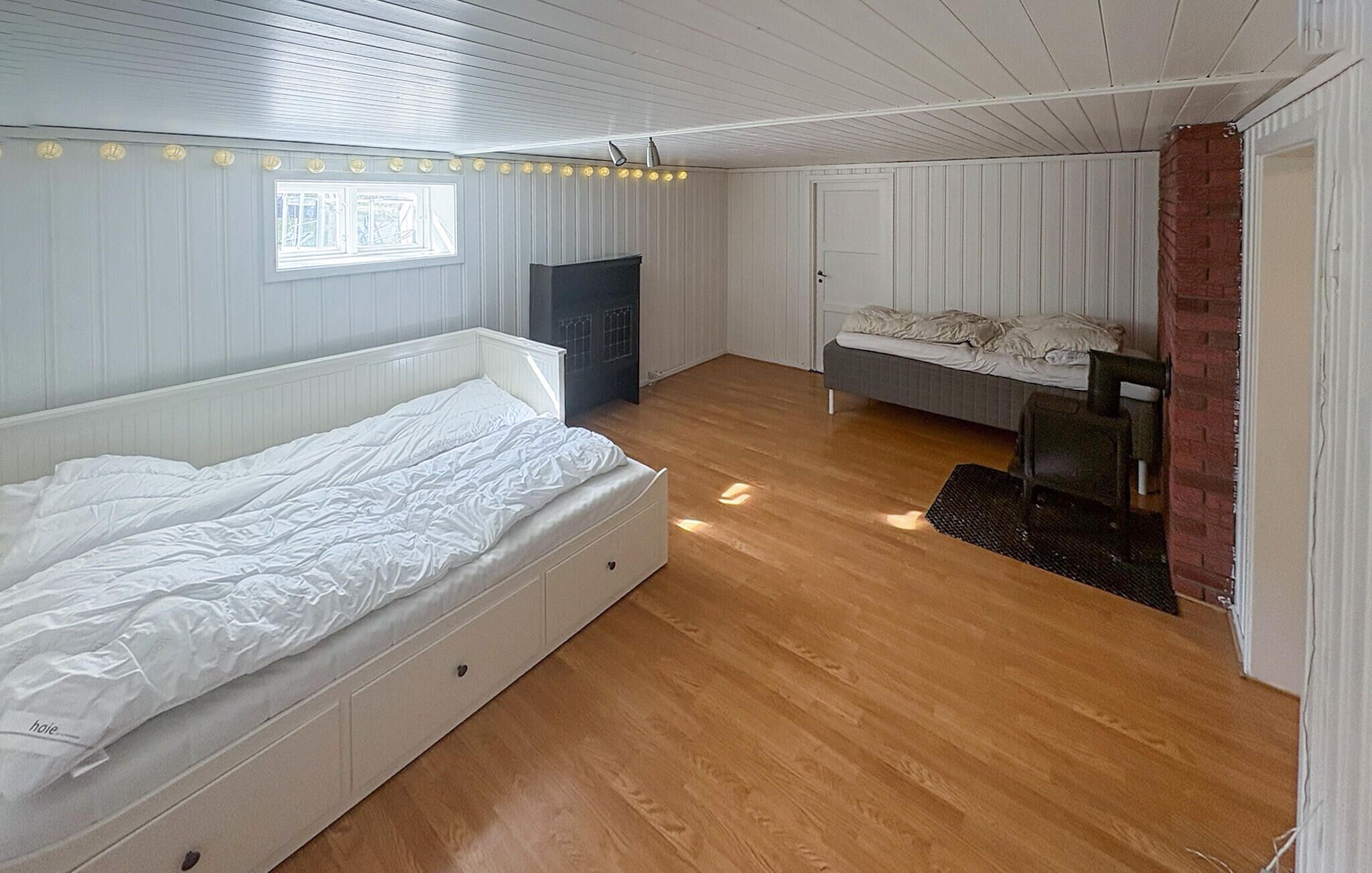 A bedroom with a large bed, a smaller bed, a desk, and a chair.