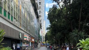 A street lined with modern buildings, a Starbucks, and pedestrians. - Pinwu Apartment (Shenzhen)