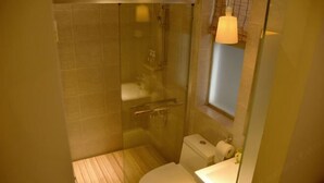 A bathroom with a glass-enclosed shower, a toilet, and a sink. - Pinwu Apartment (Shenzhen)