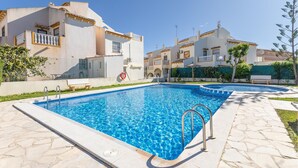 A swimming pool with clear blue water, surrounded by a stone deck and a fence. - 2 bedroom stunning home in La Zenia (La Zenia)