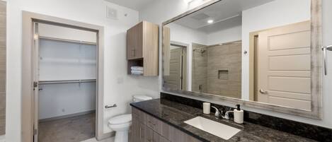 A modern bathroom with a vanity, sink, and mirror.