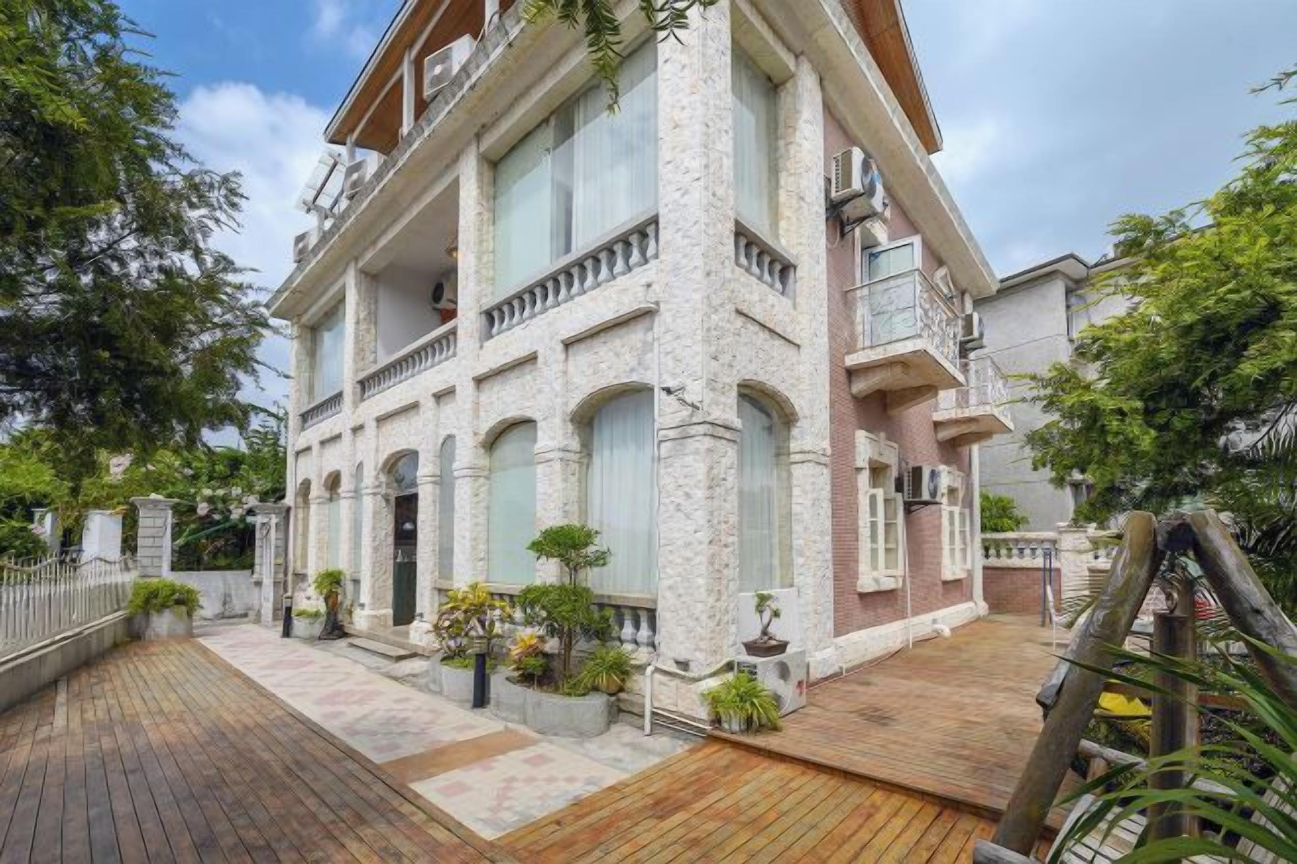 A multi-story building with a brick facade, large windows, and a wooden deck.