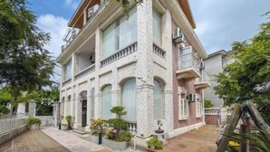 Un immeuble à plusieurs étages, doté d’une façade en pierre, de grandes fenêtres et d’une terrasse en bois.