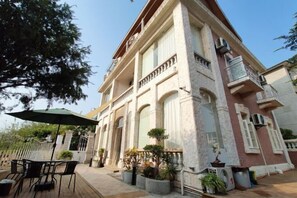A large, historic building with a balcony and outdoor seating area. - Gulangyu Qihai Homestay (Xiamen)