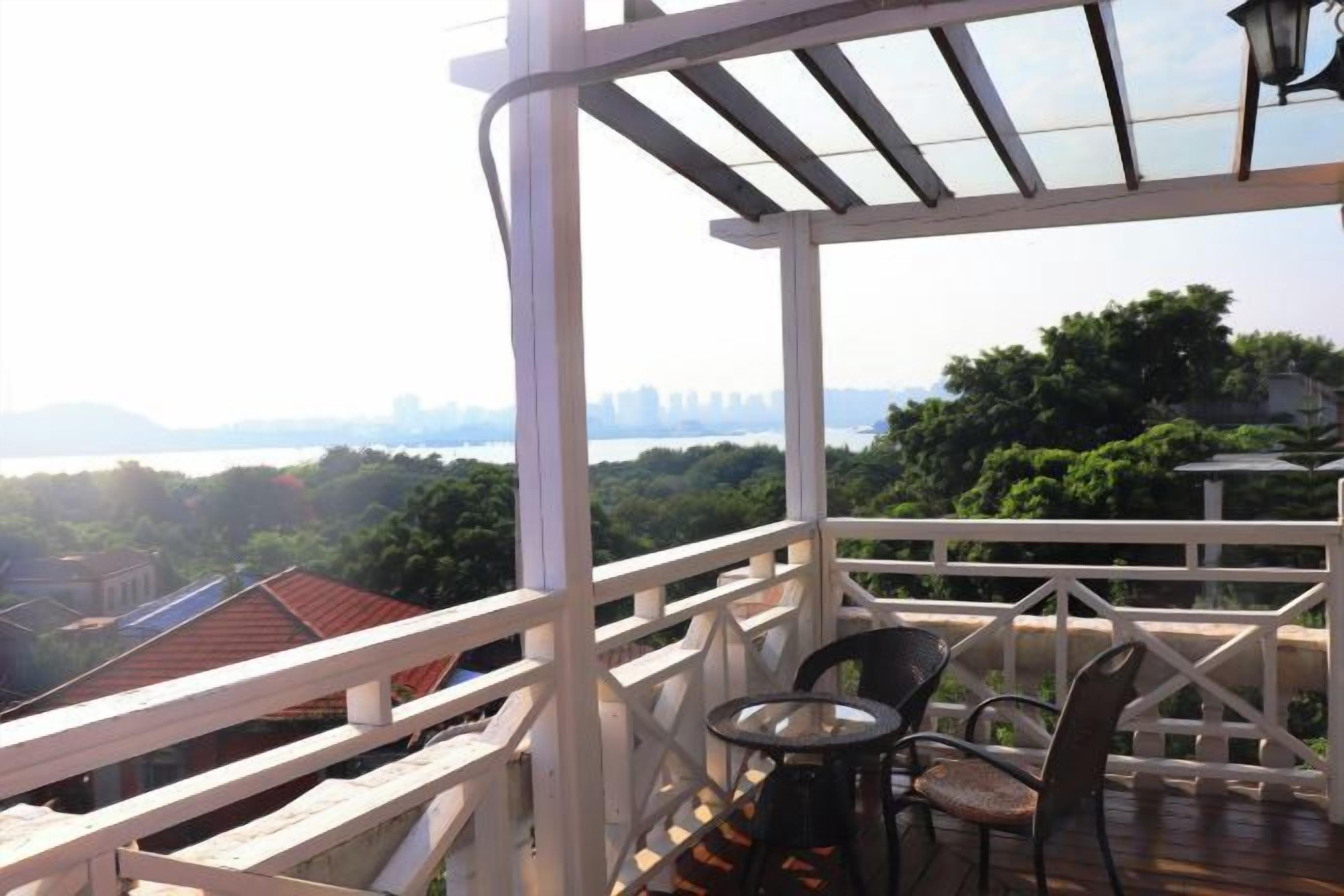 Un balcón con vistas a un horizonte urbano, una mesa y dos sillas.