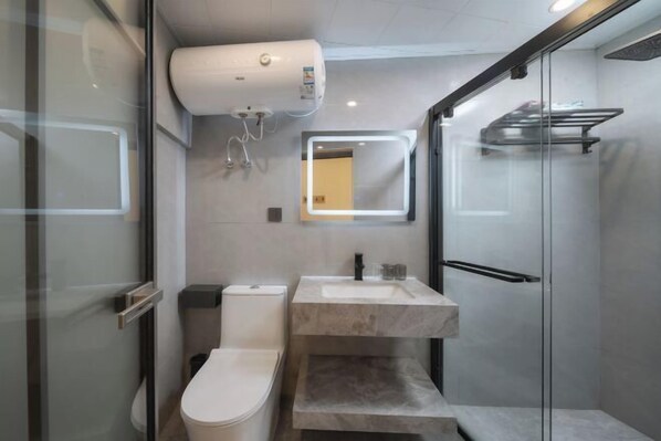 A modern bathroom with a glass shower enclosure, a toilet, and a sink with a mirror above it. - Gulangyu Qihai Homestay (Xiamen)