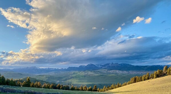 Un paysage montagneux, avec un ciel dégagé et quelques nuages épars.