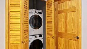 A laundry room with two stacked front-loading washing machines. - Ramblei near Chinatown & CenterCity: 2-Bedroom - Unit C (Philadelphia)