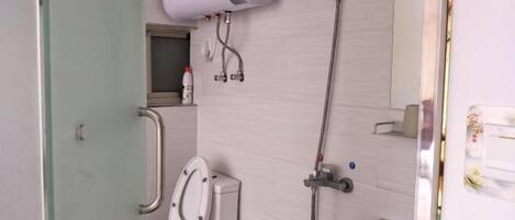 A bathroom with a toilet, bidet, and a shower.
