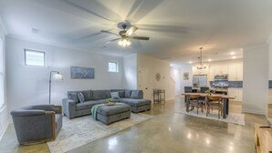 A spacious living room with a gray sectional sofa, a small gray armchair, and a dining area with a wooden table and chairs. - 2-in-1 Home! Entire Duplex for Your Private Stay (Memphis)