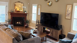 A living room with a fireplace, a television, and a sofa set.