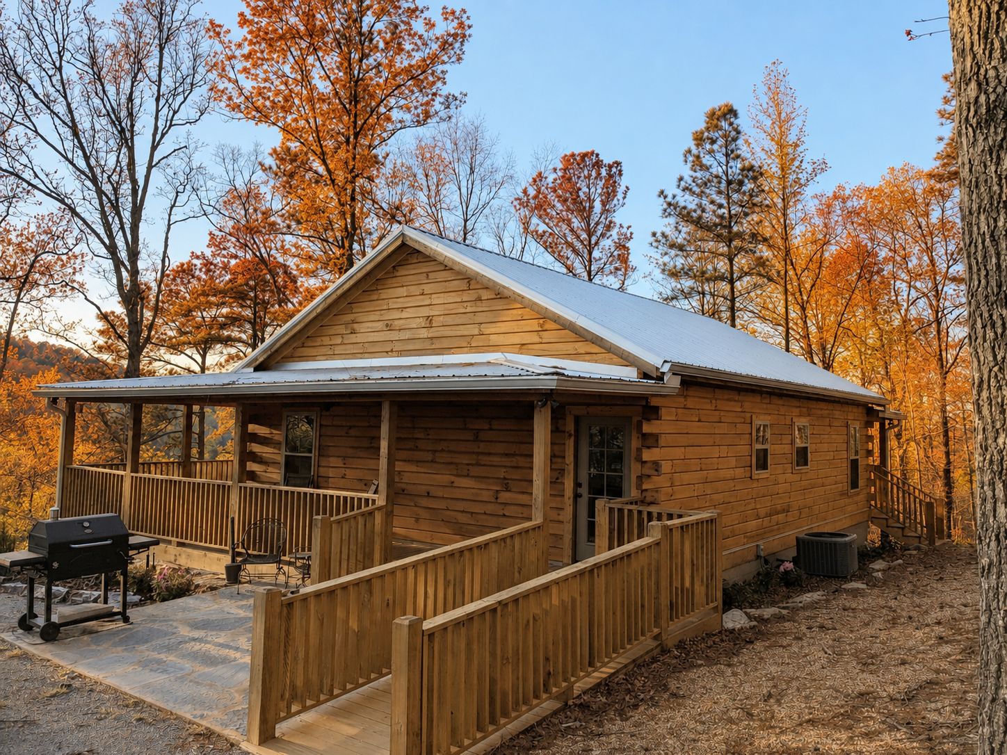 A wooden cabin with a porch, a grill, and a covered outdoor seating area.