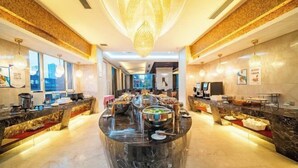 A spacious hotel lobby with a central buffet area, large windows, and a modern chandelier. - Puhua Hotel (Anshun)