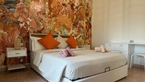 Une chambre à coucher avec un grand lit, deux tables de chevet, un bureau et un mur à texture.