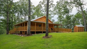 A wooden cabin with a covered porch and a separate shed, surrounded by trees and grassy area. - Pinhoti Ridge Retreat Cabin 2, Skyline (Talladega)