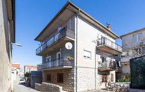 A multi-story building with balconies, stone facade, and a clear sky. - 2 bedroom awesome apartment in Novi Vinodolski (Novi Vinodolski)