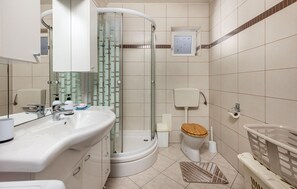 A modern bathroom with a glass shower enclosure, a toilet with a wooden seat, and a sink with a mirror. - 2 bedroom awesome apartment in Novi Vinodolski (Novi Vinodolski)