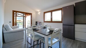 Une cuisine moderne avec un coin repas, un canapé et un réfrigérateur.