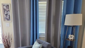 A living room with a gray sofa, a floor lamp, and a blue curtain. - Close to everything-Centrally located to downtown, coliseum, hospital, & stadium (Fayetteville)