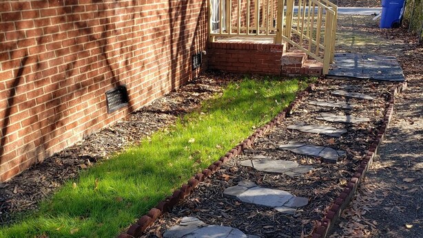 A brick house with a stone pathway leading to a wooden deck. - Close to everything-Centrally located to downtown, coliseum, hospital, & stadium (Fayetteville)