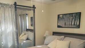 A bedroom with a bed, a ceiling fan, a painting, and a window with curtains. - Close to everything-Centrally located to downtown, coliseum, hospital, & stadium (Fayetteville)