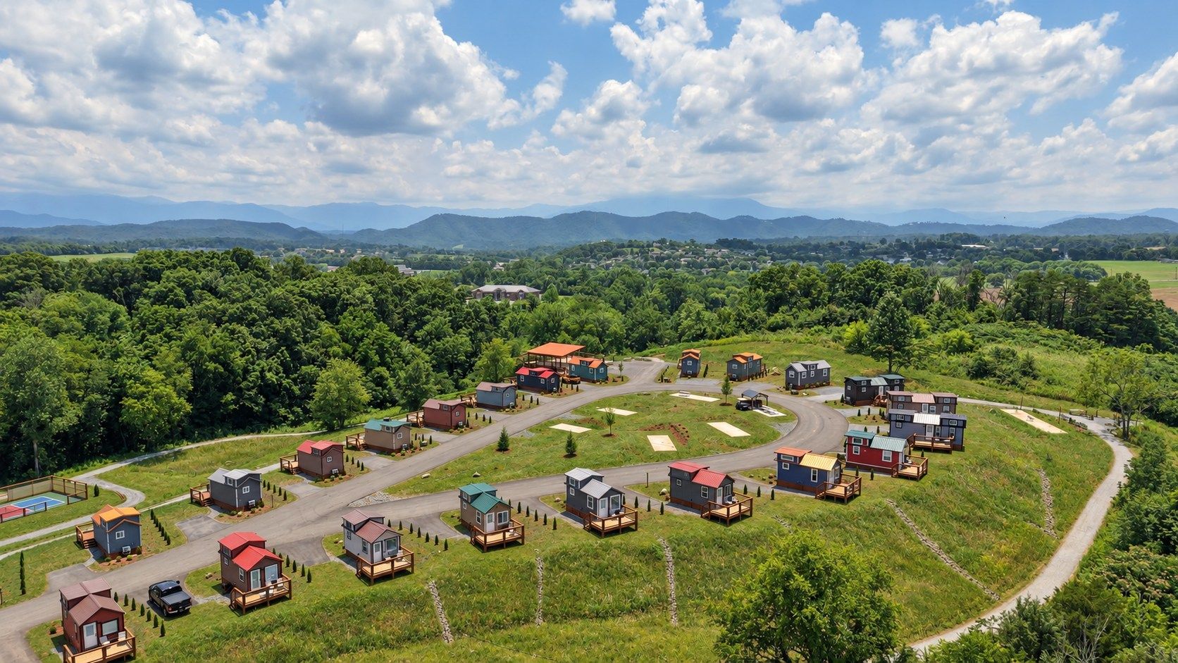 A residential area with multiple houses, roads, and a clear sky.